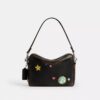 Bolso bandolera Dakota de Rexy para su décimo cumpleaños, en cuero desgastado con estampado de calcomanías