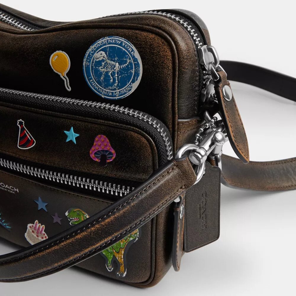 Bolso bandolera Dakota de Rexy para su décimo cumpleaños, en cuero desgastado con estampado de calcomanías