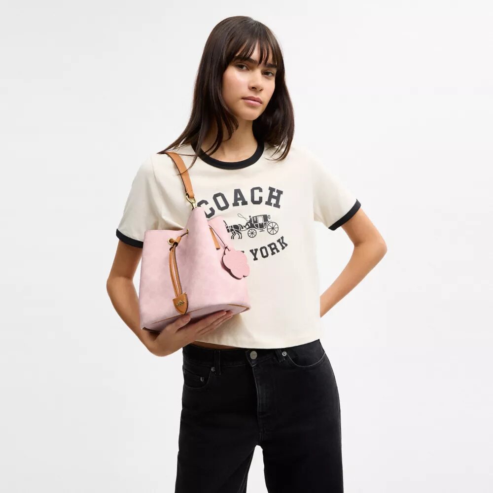Bolso tipo cubeta Rowan en Signature Canvas con Charms