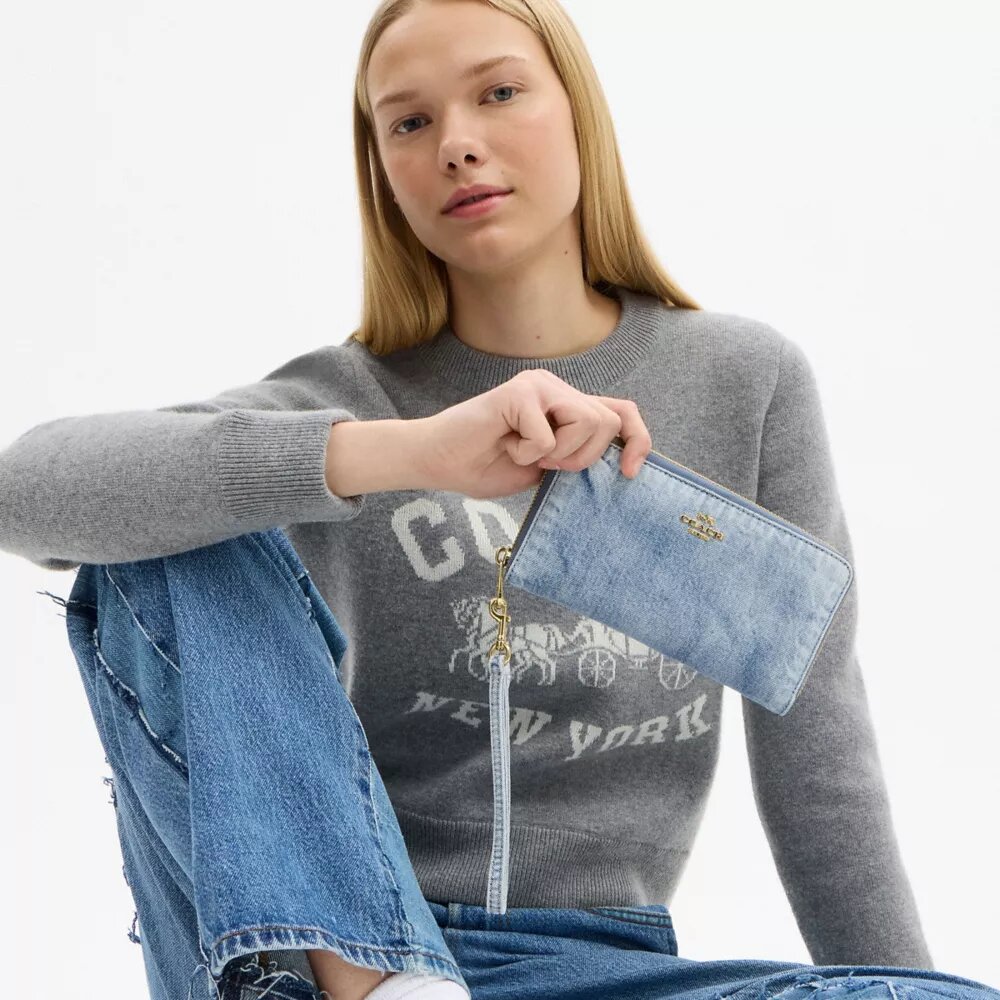 Cartera larga con cierre de cremallera alrededor en denim desgastado