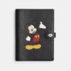 Cuaderno Disney X Coach en cuero regenerativo con Mickey Mouse