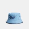 Sombrero tipo bucket de mezclilla con el logotipo «Coach Script» bordado