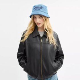 Sombrero tipo bucket de mezclilla con el logotipo «Coach Script» bordado